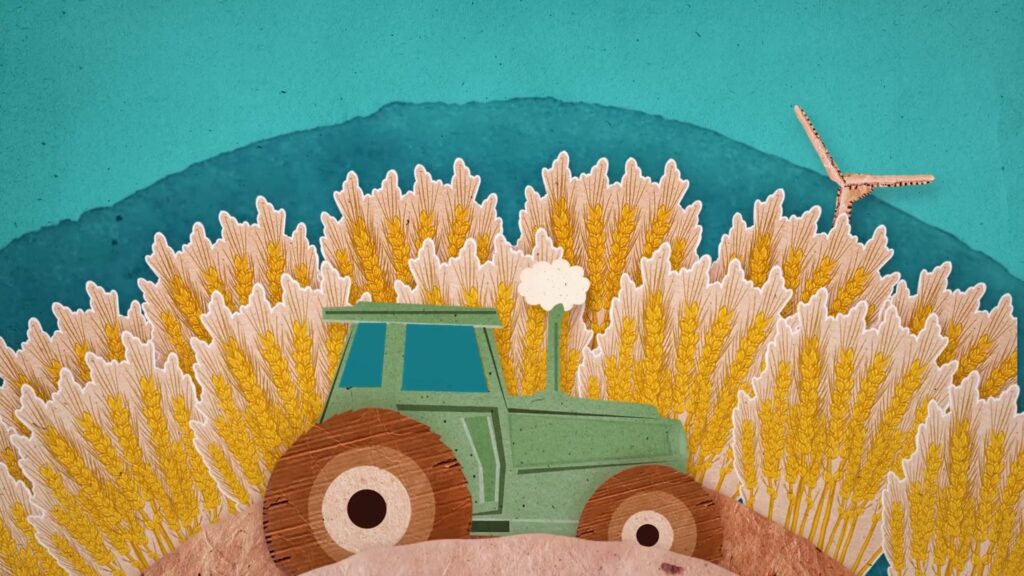 Traktori vehnäpellon edessä. Taustalla sininen taivas ja tuulimylly. Motivalle toteutettu kuvitus kartonkityylillä.